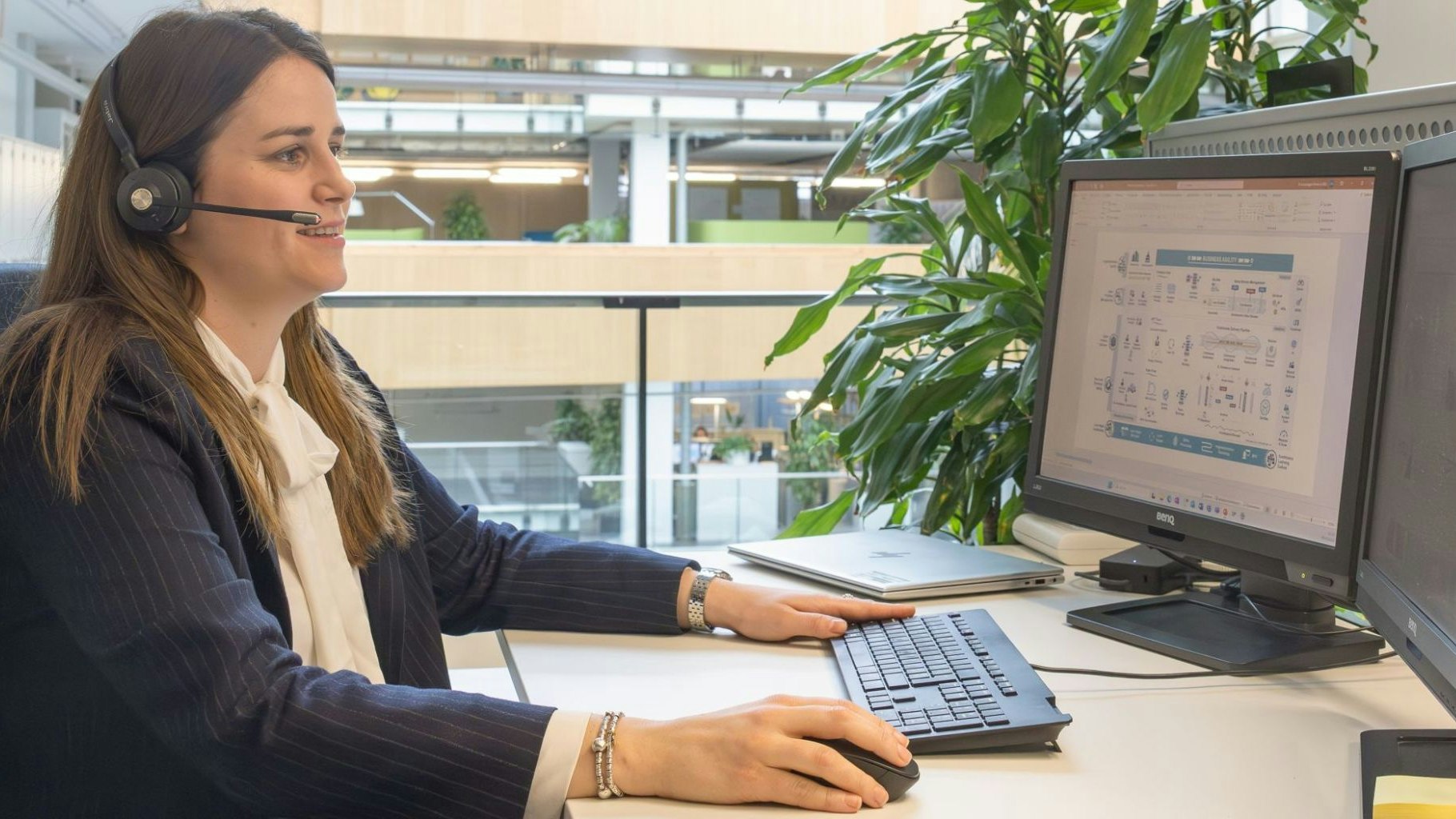 Frau mit Headset vor dem Computer