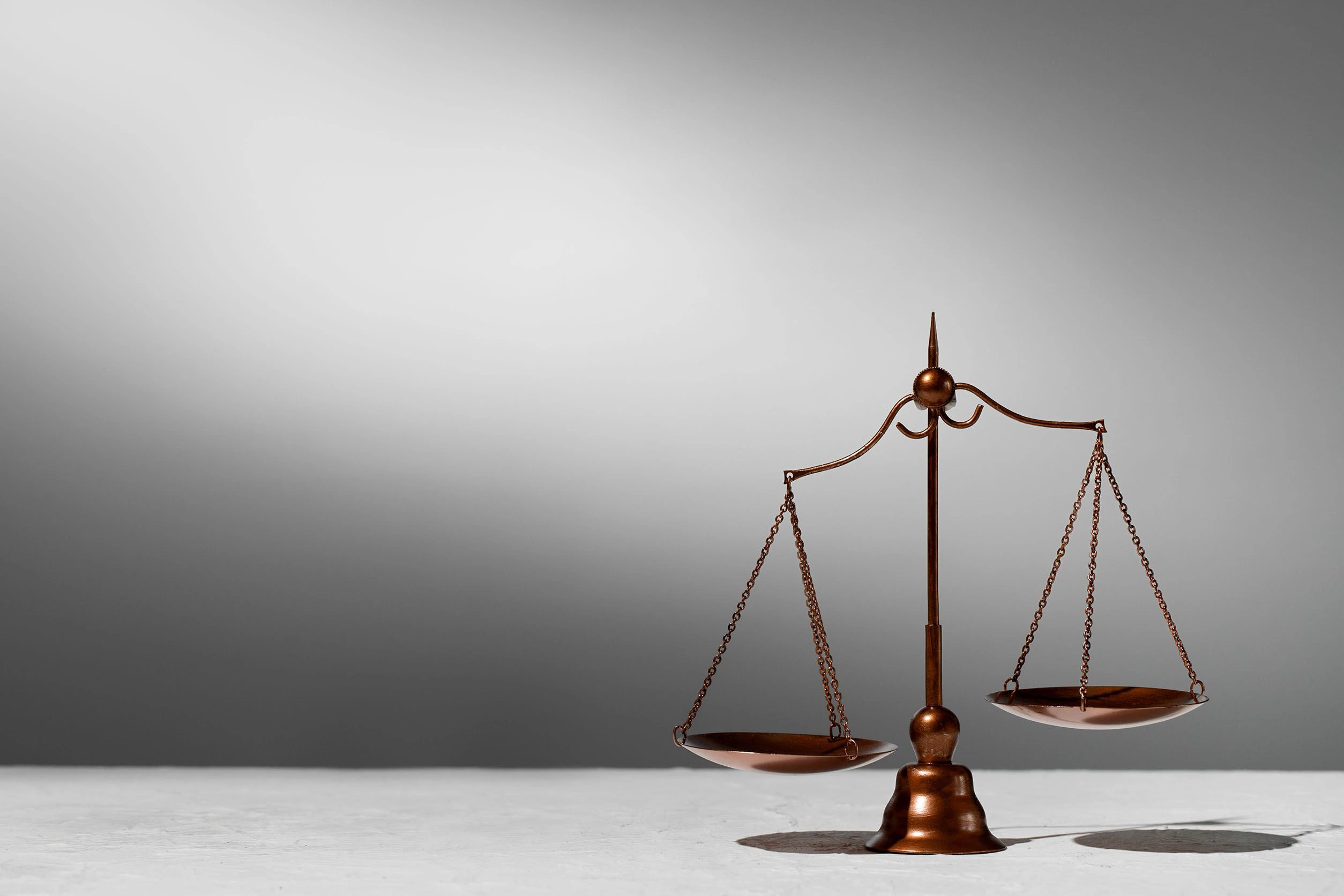 On voit une balance ancienne à plateaux en bronze. 